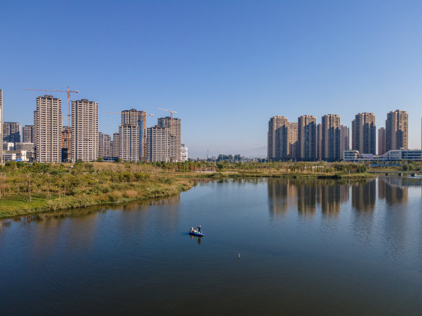 蓝天下，湖水映出城市的天际线图片下载