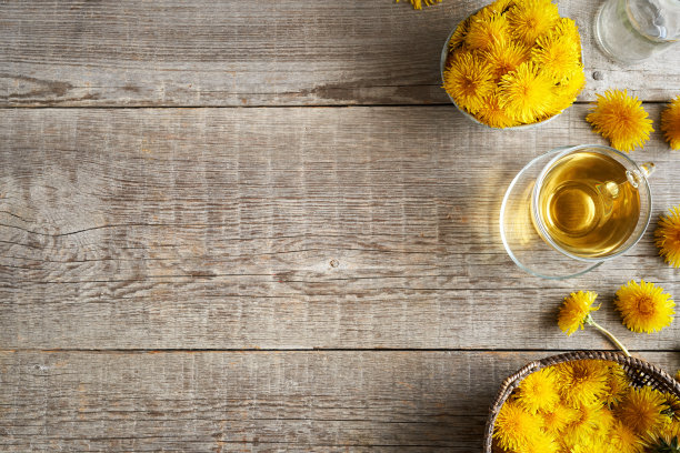 蒲公英花与一杯蒲公英茶在木制背景与拷贝空间图片下载