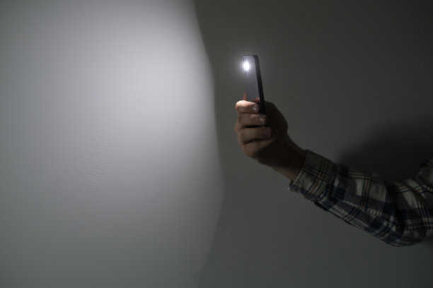 在黑暗中，手拿智能手机当手电筒图片下载