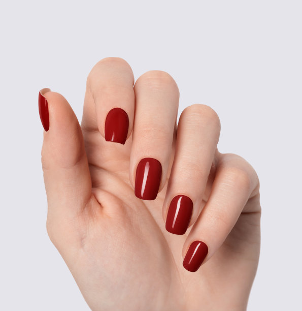 一个涂着红色指甲油的年轻女子的双手特写图片下载