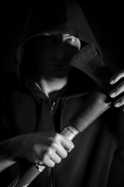 一名年轻男子的黑白肖像帽与蓝眼睛谁与斧头在他的手有一个令人不安的看图片下载