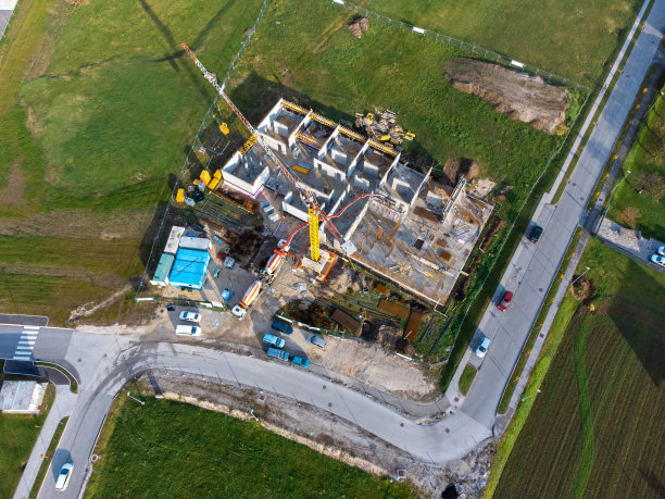 现代商业建筑在建，配有吊车等建筑设备，鸟瞰图片下载