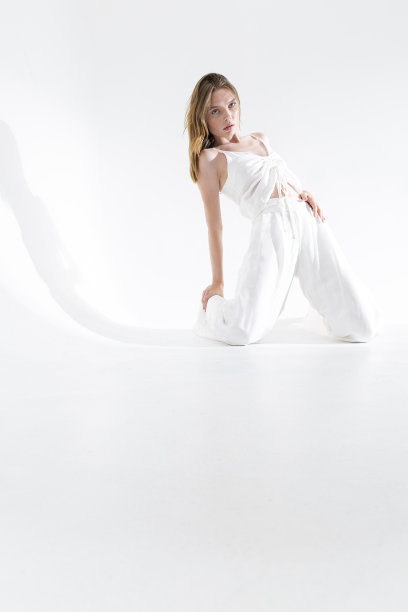 金发雀斑女孩在一个白色的背景穿着丝绸或亚麻裤子和衬衫。图片下载