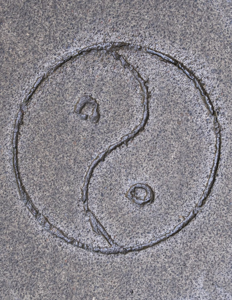 印在巴厘岛混凝土路面上的阴阳符号。背景和壁纸纹理图片下载