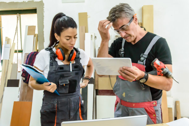 一对木匠正在用平板电脑分析办公室里的新项目。图片下载