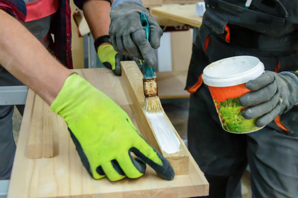 一个木匠在同事的协助下在车间工作的特写照片。图片下载