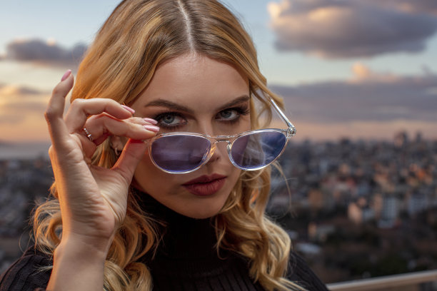 美丽的女模特戴着彩色眼镜在日落。户外浪漫的迷人的金发女人的肖像化妆和眼镜摆姿势。伊斯坦布尔群岛(公主群岛)天际线。图片下载