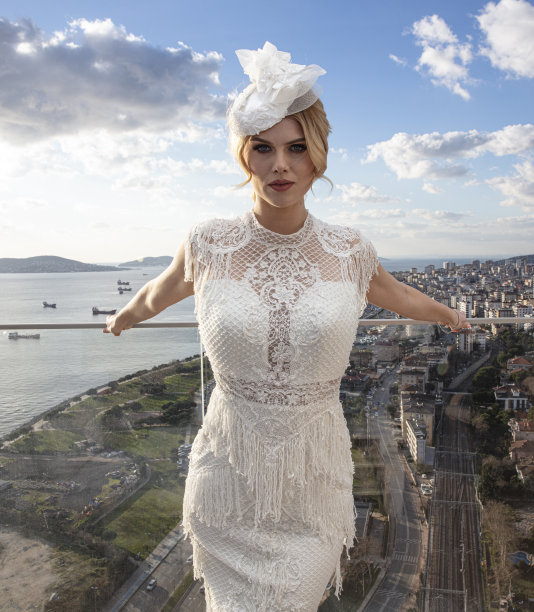 美丽的女模特在婚纱。户外浪漫的迷人的金发女子化妆和婚礼发型在阳台上对伊斯坦布尔的看法。图片下载
