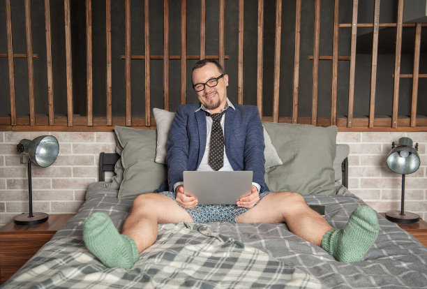穿着西装和内裤在家工作的男人躺在床上上网图片下载