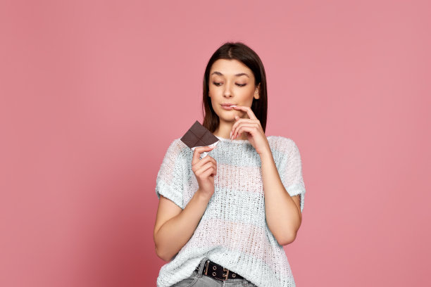 穿着毛衣的年轻女子拿着巧克力棒图片下载