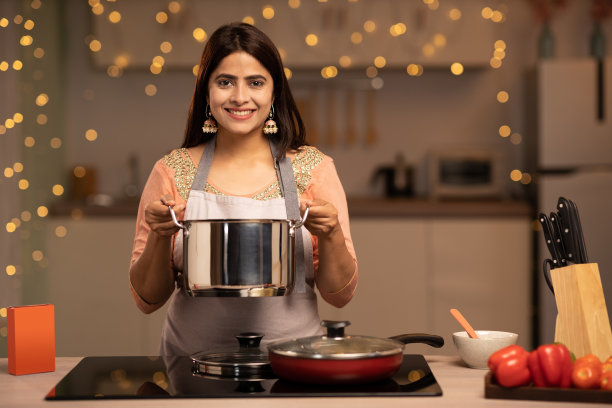 快乐的女人享受做饭在厨房，股票照片图片下载