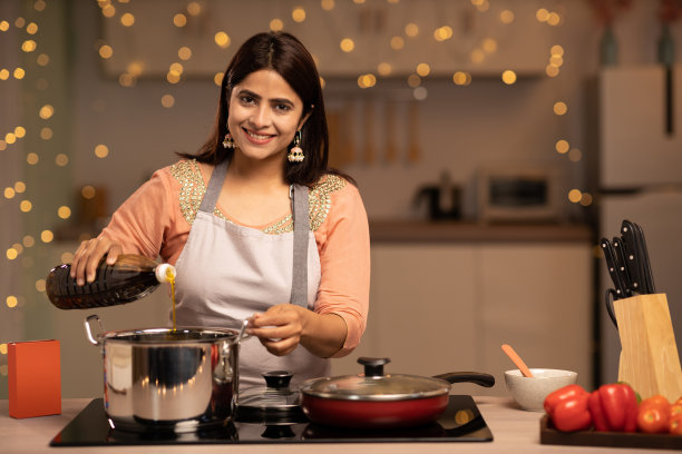 快乐的女人享受做饭在厨房，股票照片图片下载