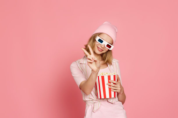 漂亮的金发女孩拿着一桶爆米花图片下载