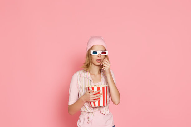 害怕的女孩看恐怖电影，抱着一桶爆米花图片下载