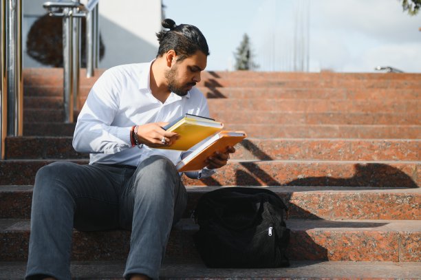 印度男学生拿着书站在大学里。图片下载