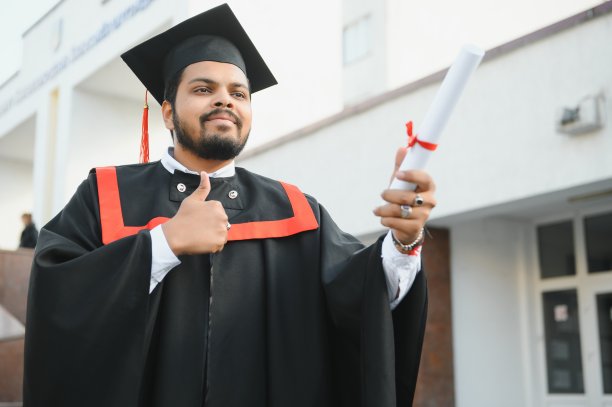 英俊的印度研究生毕业的肖像与文凭发光。图片下载