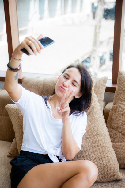 年轻的白人女性坐在咖啡馆自拍。使用社交媒体图片下载