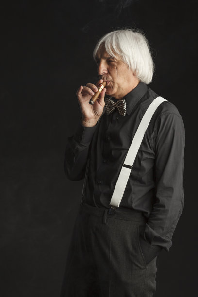 吸烟的老年男子拿着和享受他的古巴雪茄。疤痕的脸。的肖像图片下载