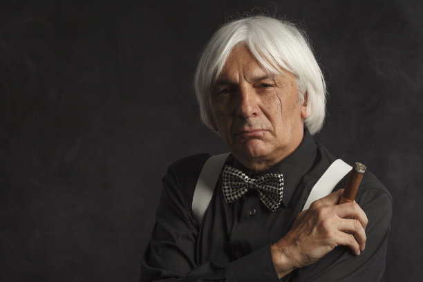 吸烟的老年男子拿着和享受他的古巴雪茄。疤痕的脸。的肖像图片下载