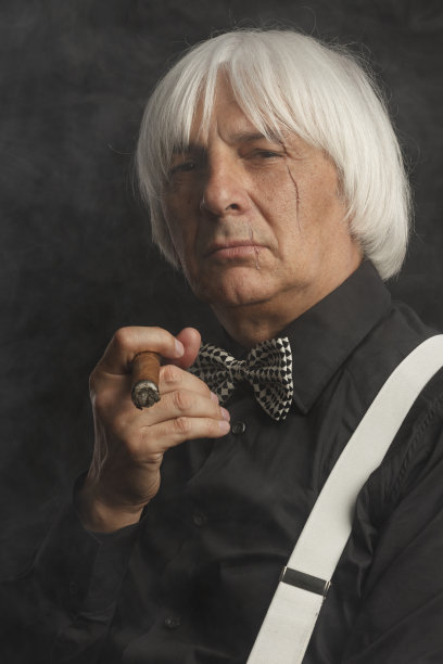 吸烟的老年男子拿着和享受他的古巴雪茄。疤痕的脸。的肖像图片下载