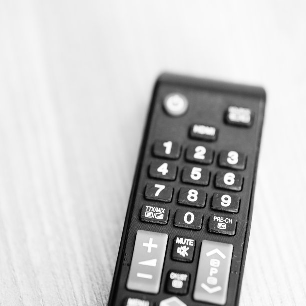 在木桌上的Savio品牌电视遥控器的特写镜头图片下载