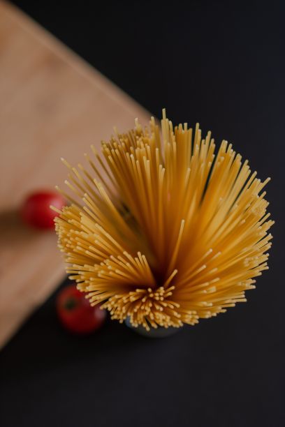 俯视图的一杯生意大利面准备煮与圣女果图片下载