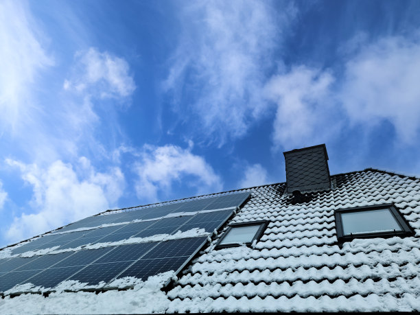 太阳能电池板在一个被雪覆盖的住宅屋顶上生产清洁能源。图片下载