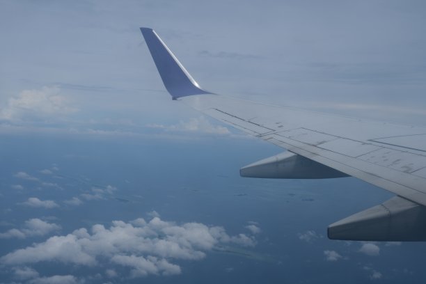 飞机机翼起飞后在天空中飞行。从机翼上的窗户看出去图片下载