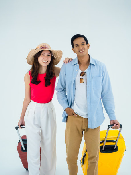 情侣旅行者，快乐的假期与友谊。暑假。年轻的亚洲男人和女人穿着五颜六色的服装看着镜头，走手提箱孤立在白色背景，垂直风格。图片下载