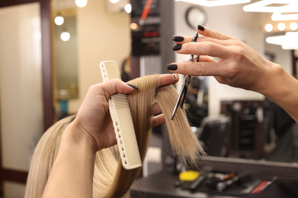 专业美发师在沙龙剪女人的头发，特写图片下载