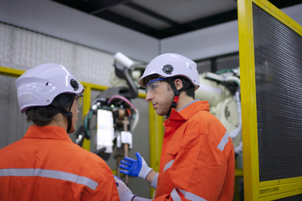 技术人员用机械臂工作。图片下载