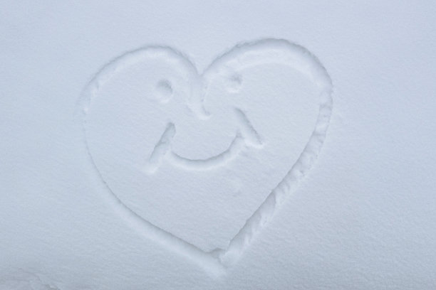 在飘落的雪花上画一颗心。爱情和迷恋的象征图片下载