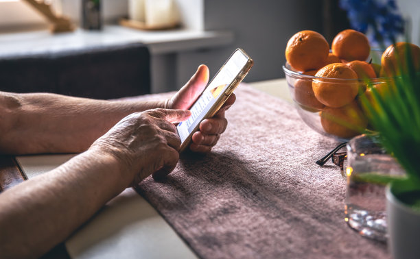 一位老妇人的手拿着手机。图片下载