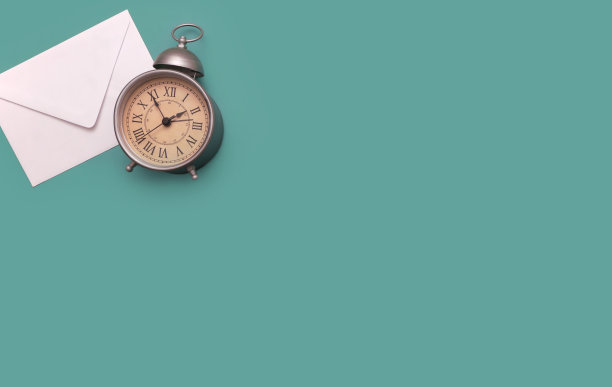 头顶上平放着一个信封和一个老式闹钟图片下载