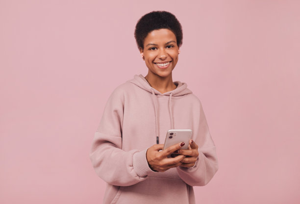 微笑兴奋的黑人女孩从无线耳机听音乐。图片下载