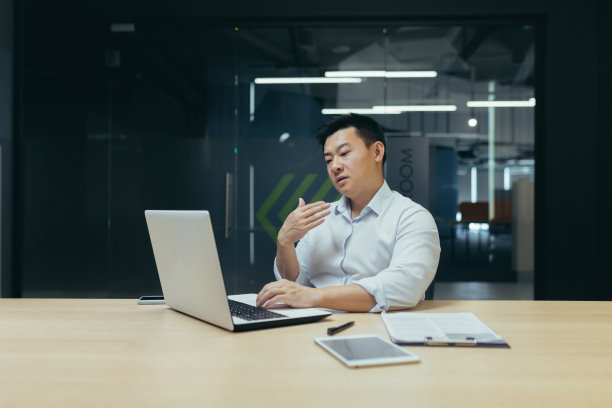 办公室里坐着一位亚洲人。他在脸上挥挥手。他感觉很糟糕，感觉很热图片下载