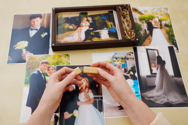 打印的婚纱照，一个木盒子和手上的优盘图片下载