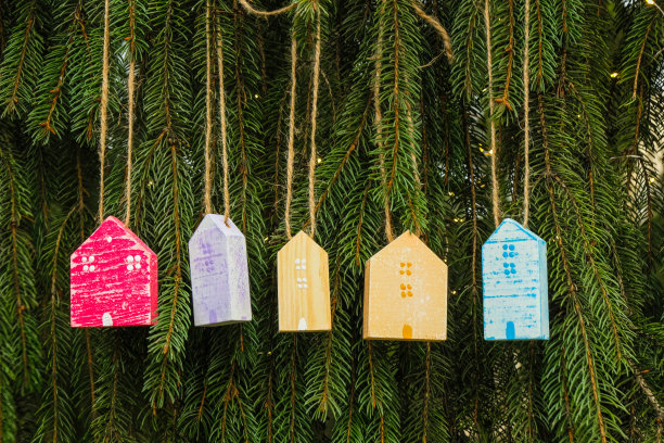 云杉背景上的彩色木屋。房地产圣诞大甩卖。图片下载