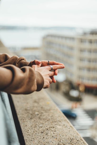 特写人物的手与银戒指在窗台上图片下载