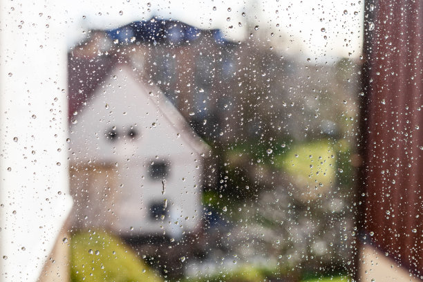 玻璃上的雨滴模糊了城市景观图片下载