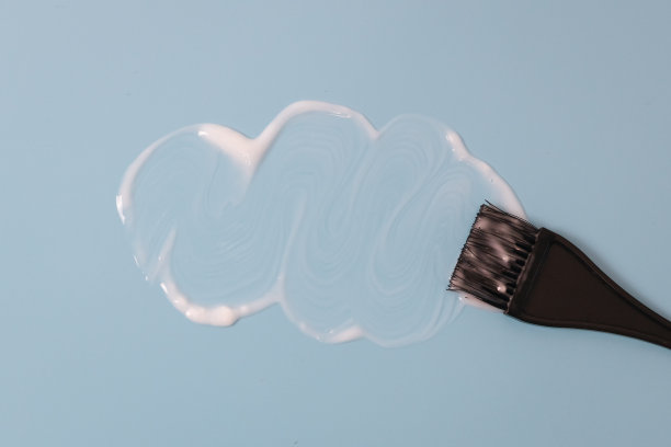 染发剂刷和涂抹白色油漆在蓝色。图片下载