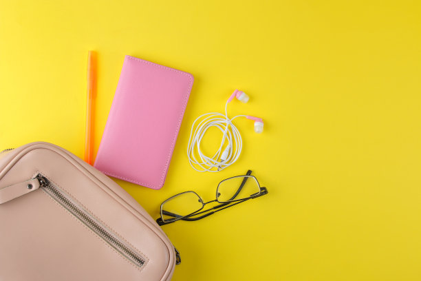 时尚时尚的粉色包包和女性配饰在明亮的潮流黄色背景。女性配饰概念。俯视图图片下载