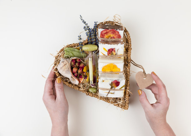 用手工压制的花纸包裹的天然自制肥皂放在心形的篮子里。公司或个人礼物的想法。妇女节，情人节，母亲节的礼物。图片下载