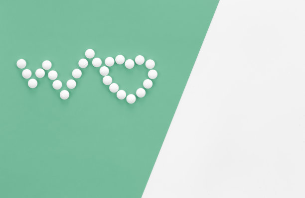 散落在绿色背景上的心形药丸，平铺。图片下载