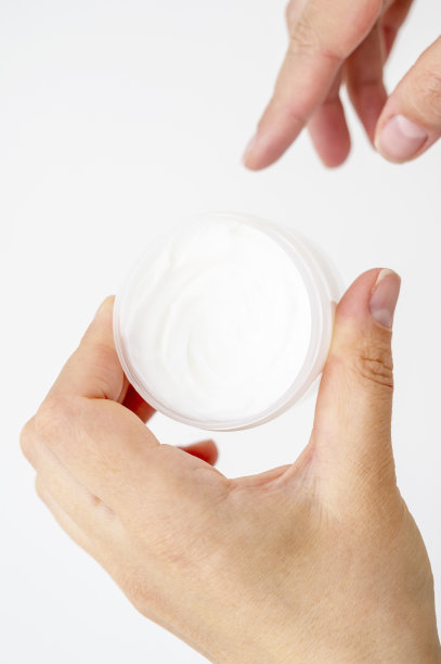 皮肤护理产品。女性手拿面霜罐在明亮的背景。美容护肤品图片下载