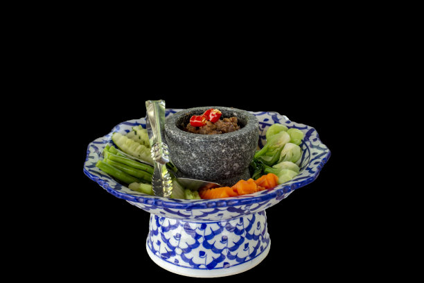 黑背景上的辣椒酱拌煮蔬菜图片下载