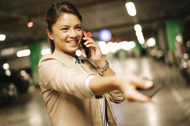 年轻的女商人在车库里使用电话。图片下载