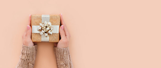 旗帜礼盒在女性手中的米色背景与文字的地方图片下载