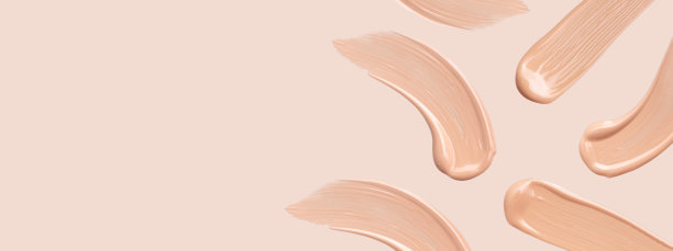 在米色背景上涂抹粉底霜图片下载