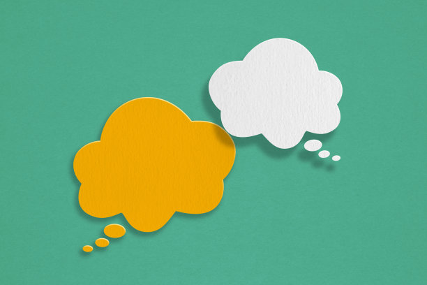 橙色和白色的演讲云气泡纸剪纸在垃圾绿纸背景。关于沟通和社交媒体的概念形象，客户反馈图片下载